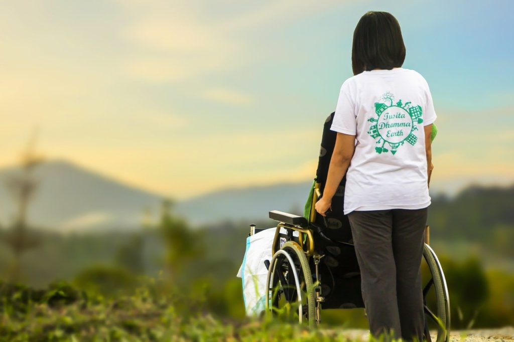 A imagem mostra duas pessoas olhando para o horizonte: um paciente e seu cuidador