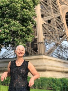 A imagem mostra Luzia que fez a doação de corpo posando sorridente em frente à Torre Eiffel em Paris em 2019.